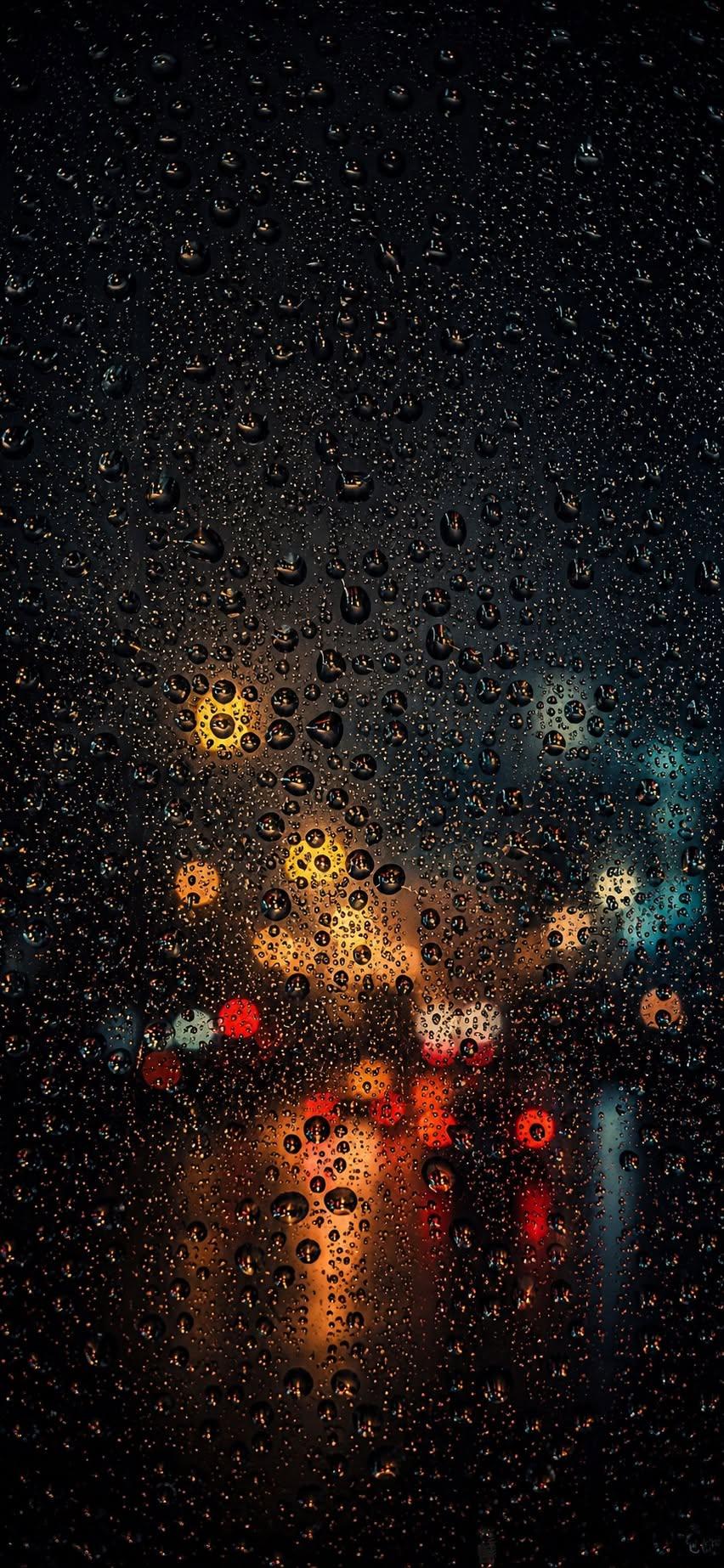 Rainy window wallpaper with raindrops and blurred bokeh city lights